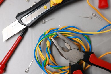 Photo of Different electrical tools on grey table, flat lay