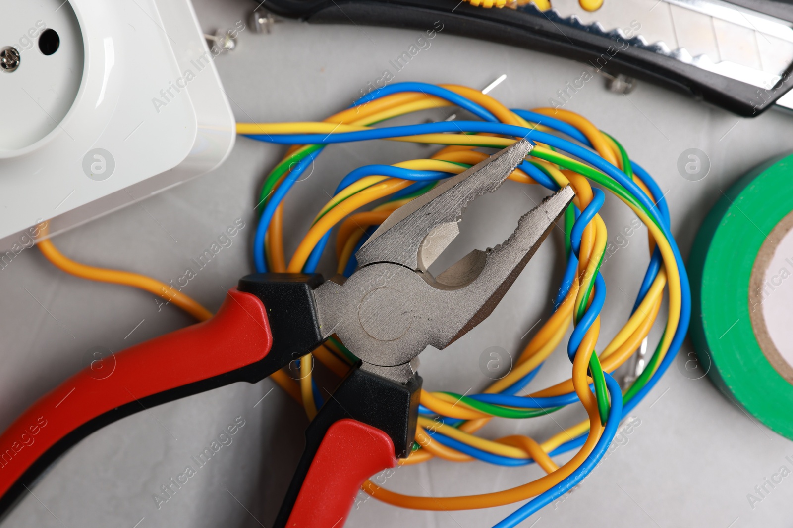 Photo of Different electrical tools on grey table, flat lay