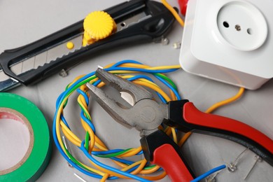 Photo of Different electrical tools on grey table, above view