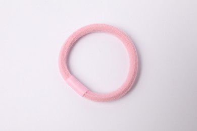 Photo of One pink hair tie on white background, top view