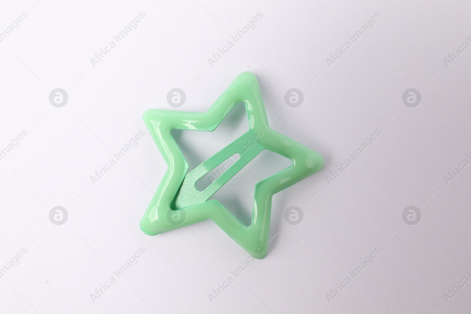 Photo of One green star shaped hair clip on white background, top view