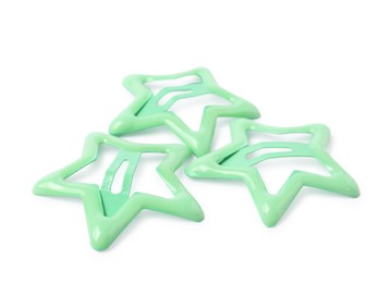 Photo of Many green star shaped hair clips isolated on white