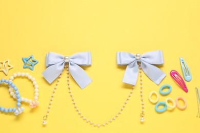 Photo of Cute hair accessories on yellow background, flat lay. Space for text