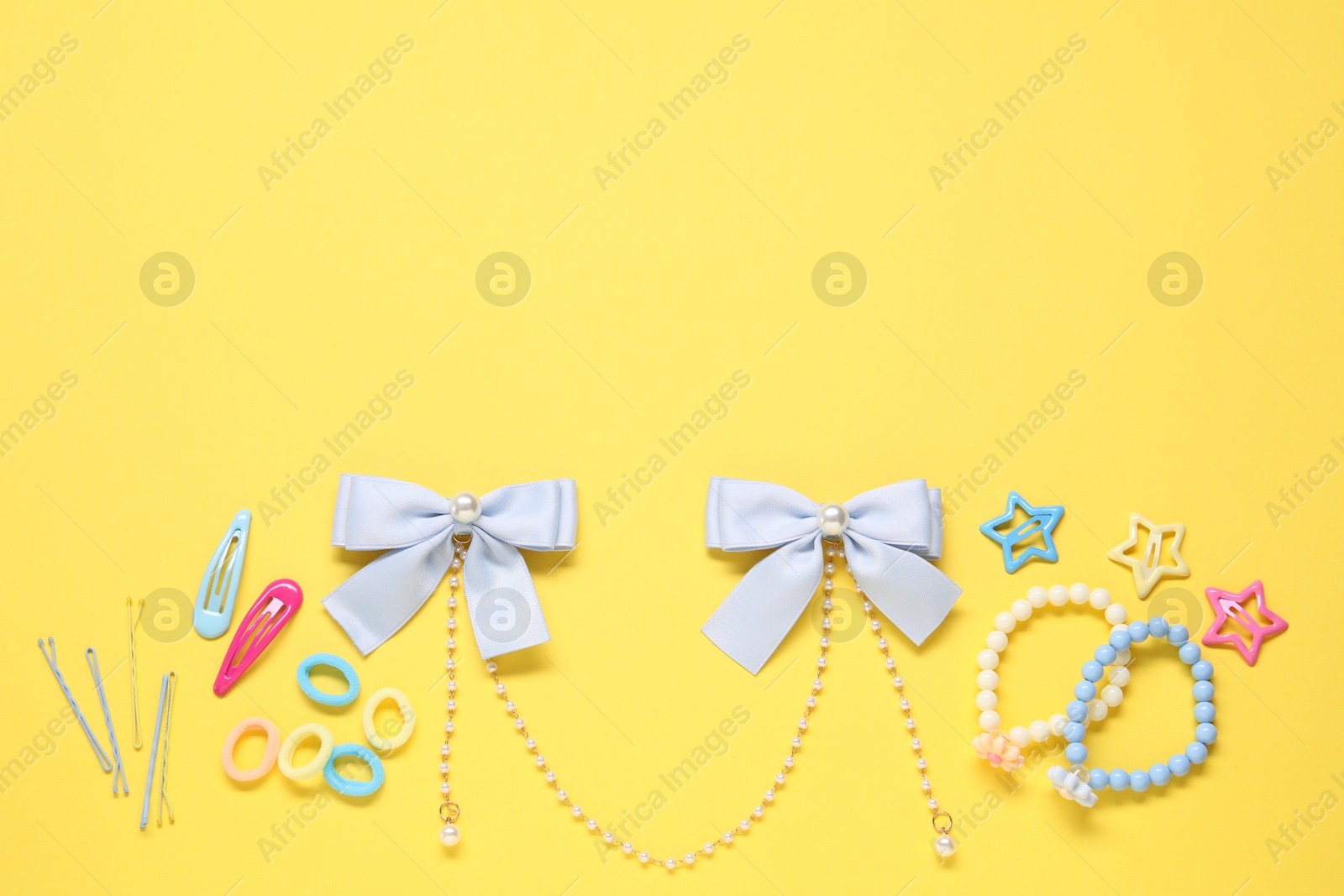 Photo of Cute hair accessories on yellow background, flat lay. Space for text