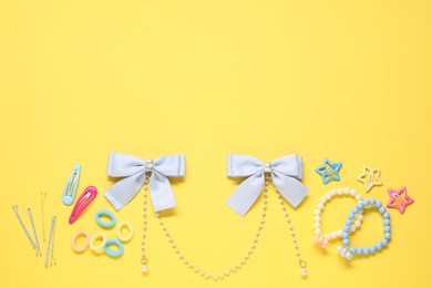 Photo of Cute hair accessories on yellow background, flat lay. Space for text