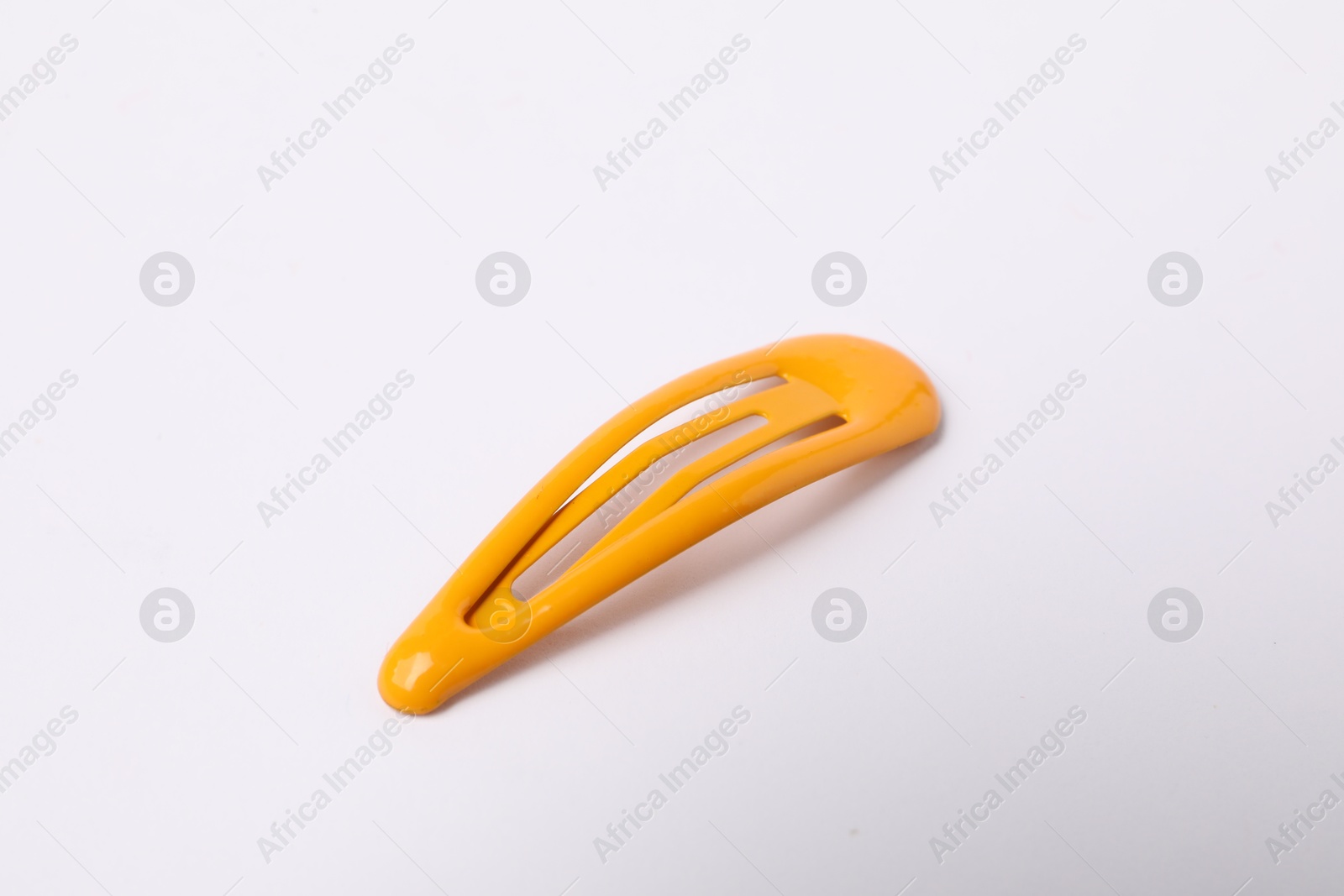 Photo of One orange hair clip on white background