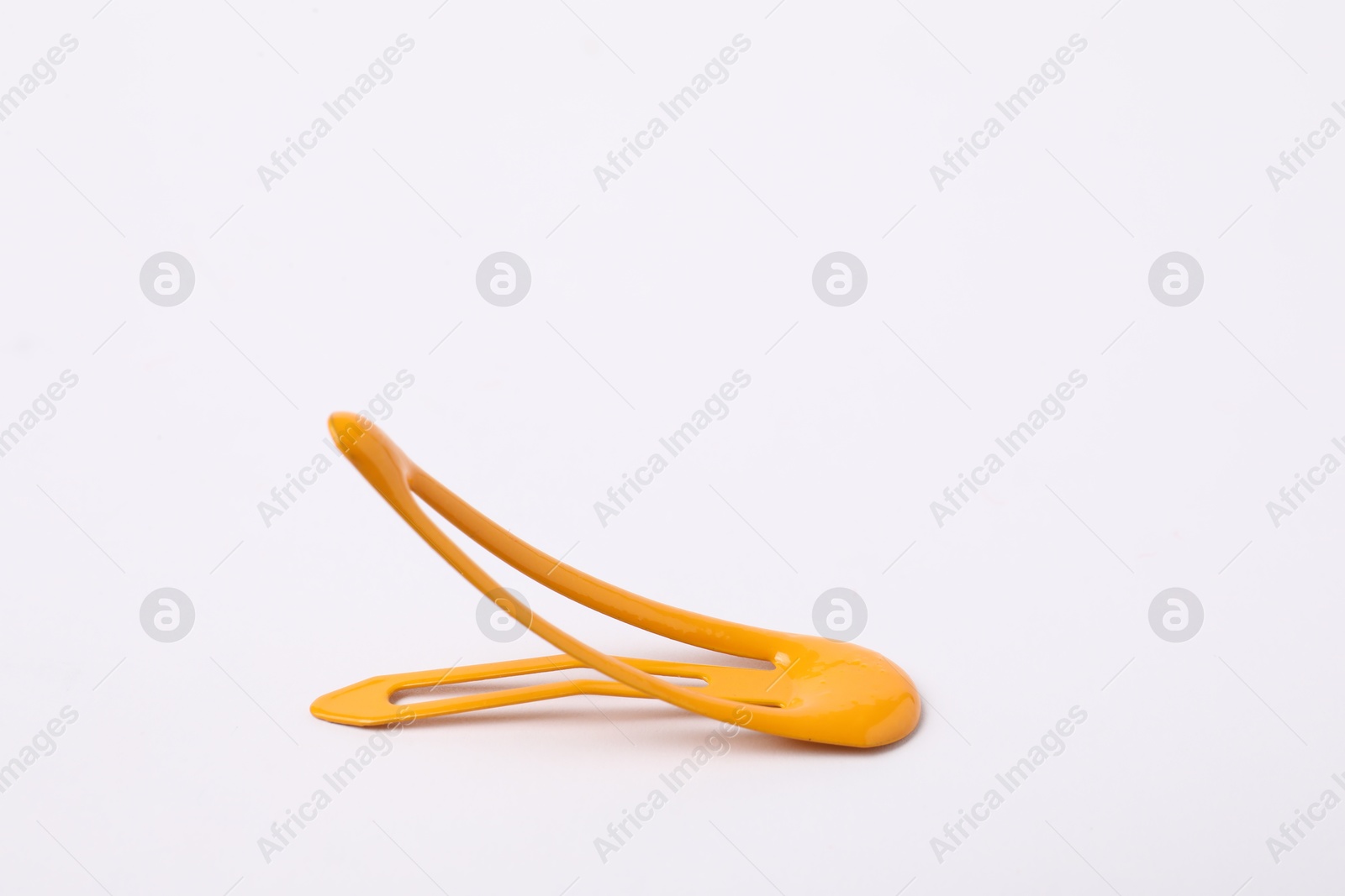 Photo of One orange hair clip on white background