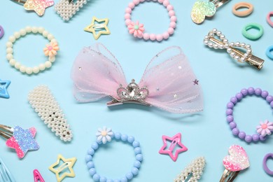 Photo of Cute hair accessories on light blue background, flat lay