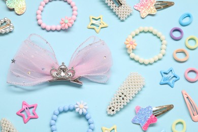 Photo of Cute hair accessories on light blue background, flat lay