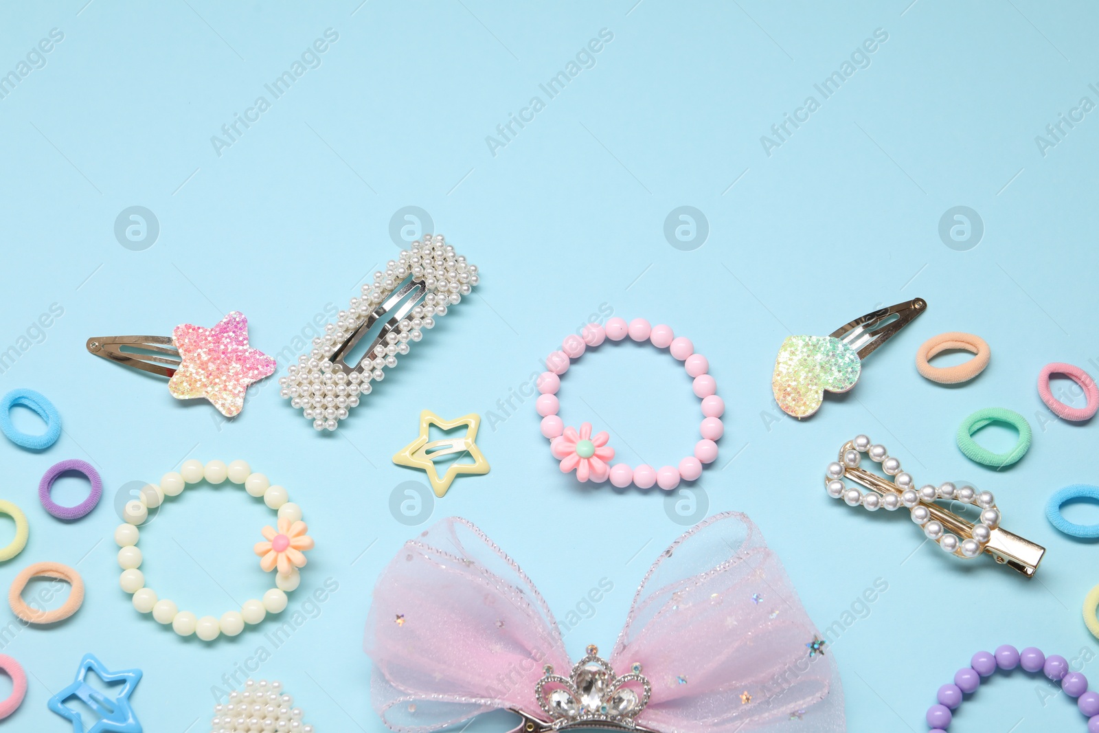 Photo of Cute hair accessories on light blue background, flat lay