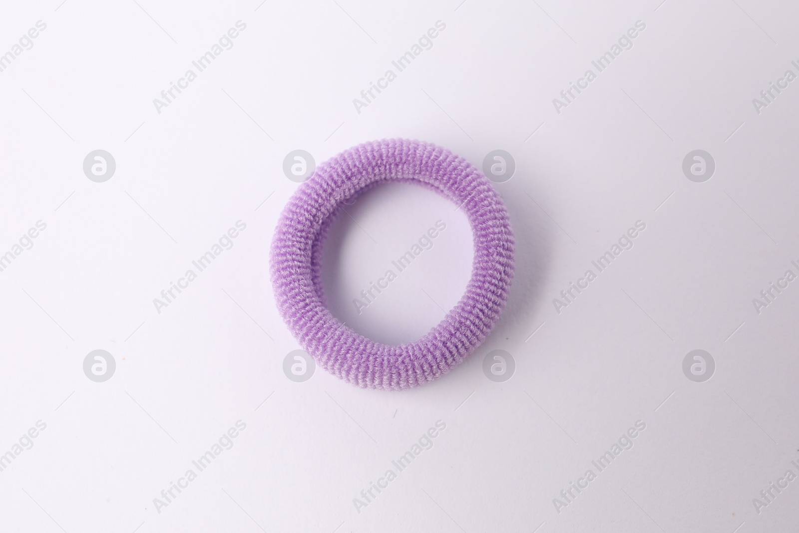 Photo of One violet hair tie on white background, top view