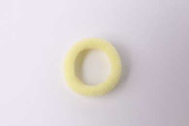 Photo of One yellow hair tie on white background, top view