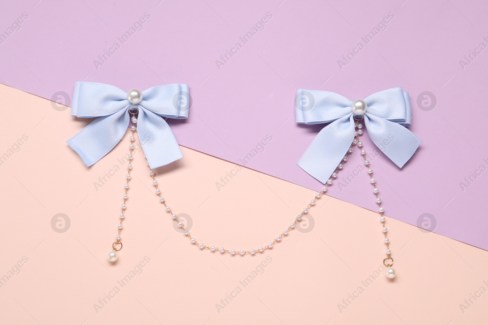 Photo of Beautiful hair bows with beads on color background, top view