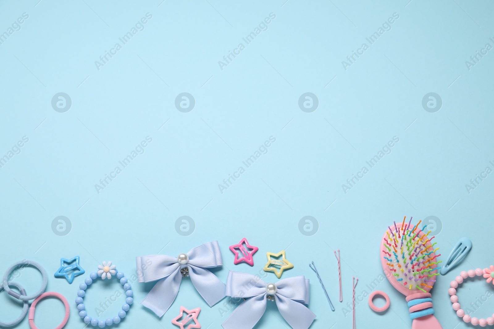 Photo of Cute hair accessories on light blue background, flat lay. Space for text