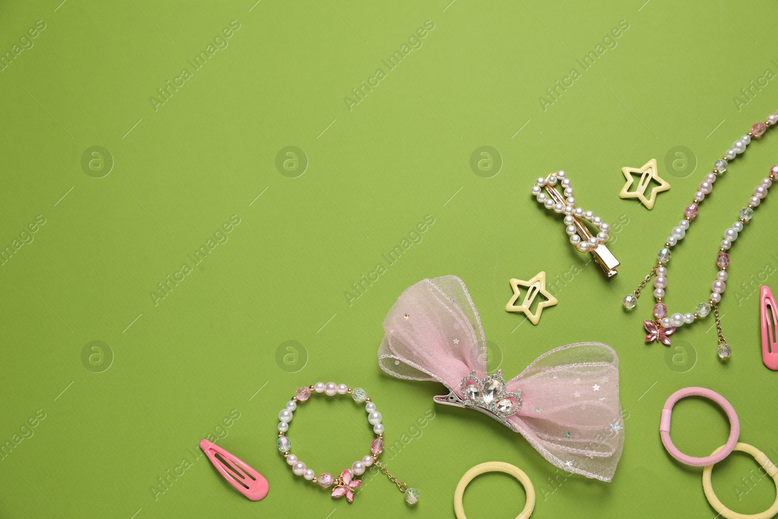 Photo of Cute hair accessories on green background, flat lay. Space for text