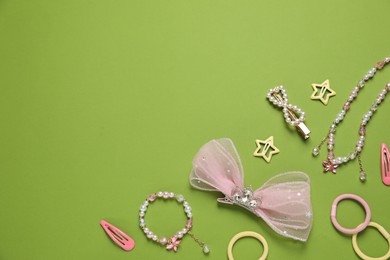 Photo of Cute hair accessories on green background, flat lay. Space for text