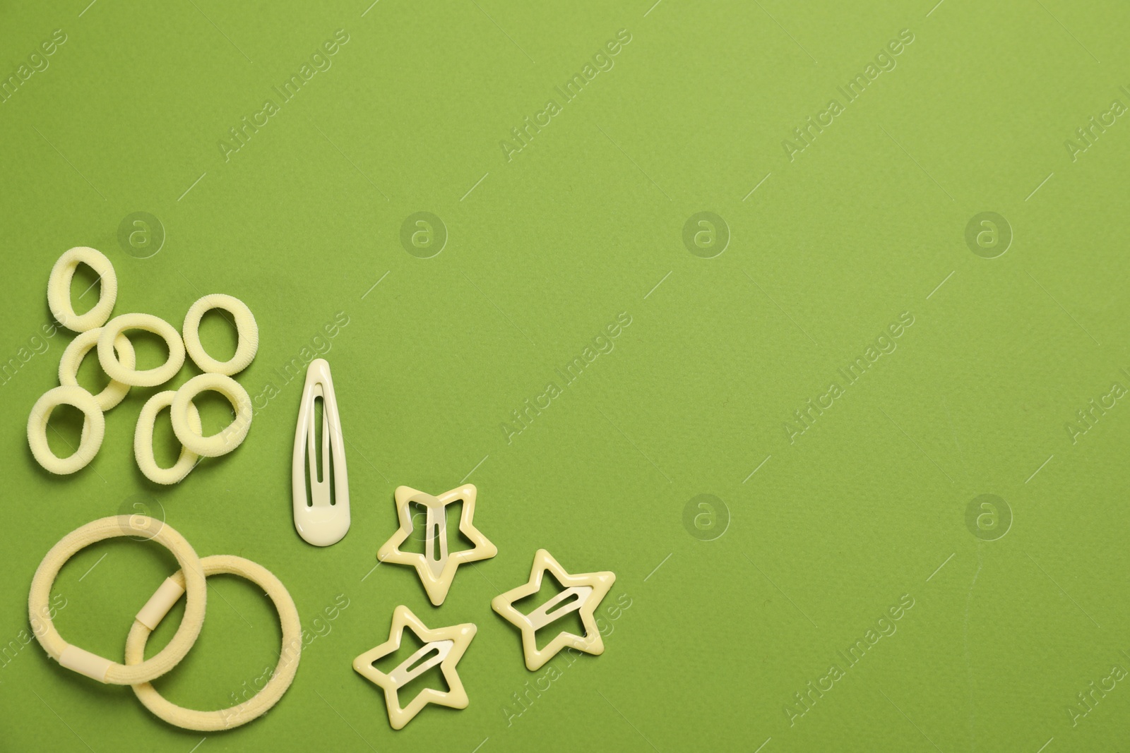 Photo of Cute hair accessories on green background, flat lay. Space for text