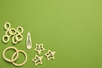 Photo of Cute hair accessories on green background, flat lay. Space for text