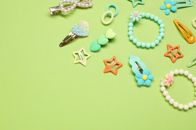 Photo of Cute hair accessories on green background, flat lay. Space for text