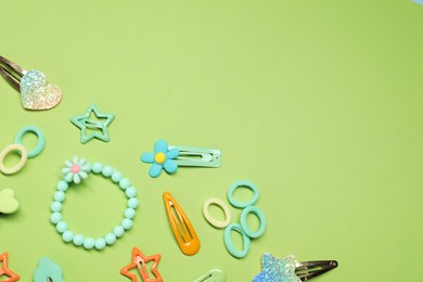 Photo of Cute hair accessories on green background, flat lay. Space for text