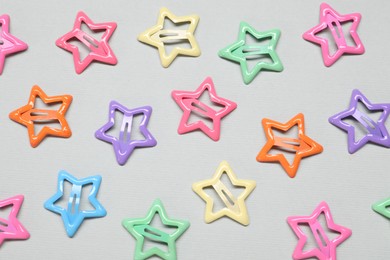 Photo of Colorful star shaped hair clips on light grey background, flat lay