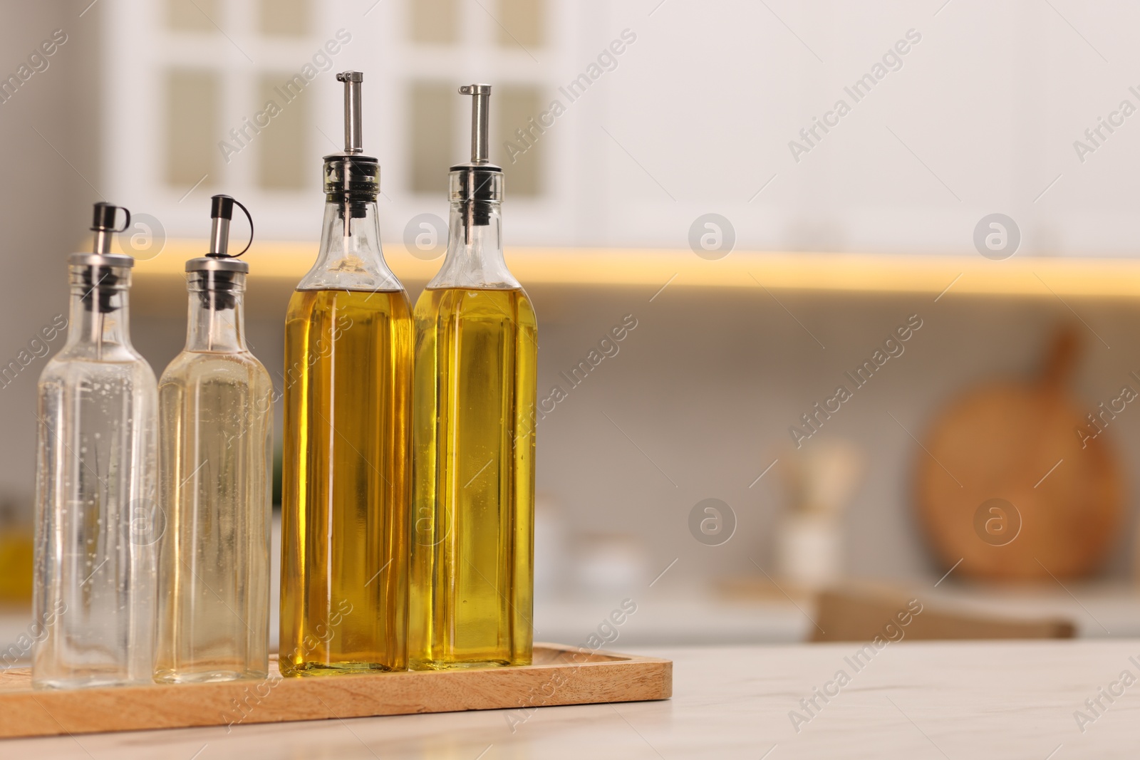 Photo of Bottles of salad dressings on white table in kitchen, space for text