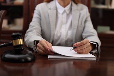 Photo of Judge working with documents at table in office, closeup