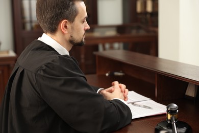 Photo of Judge working with documents at table in office