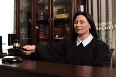 Photo of Judge striking gavel at table in courtroom