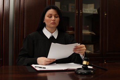 Photo of Judge working with documents at wooden table in office