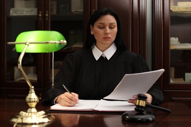 Photo of Judge working with documents at wooden table in office