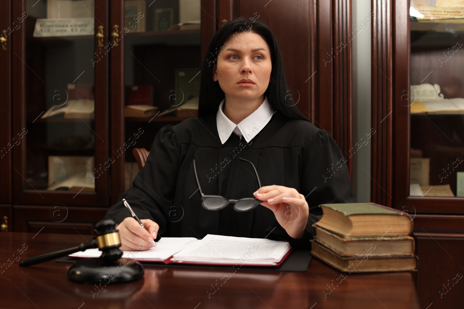 Photo of Judge with glasses working at table in office