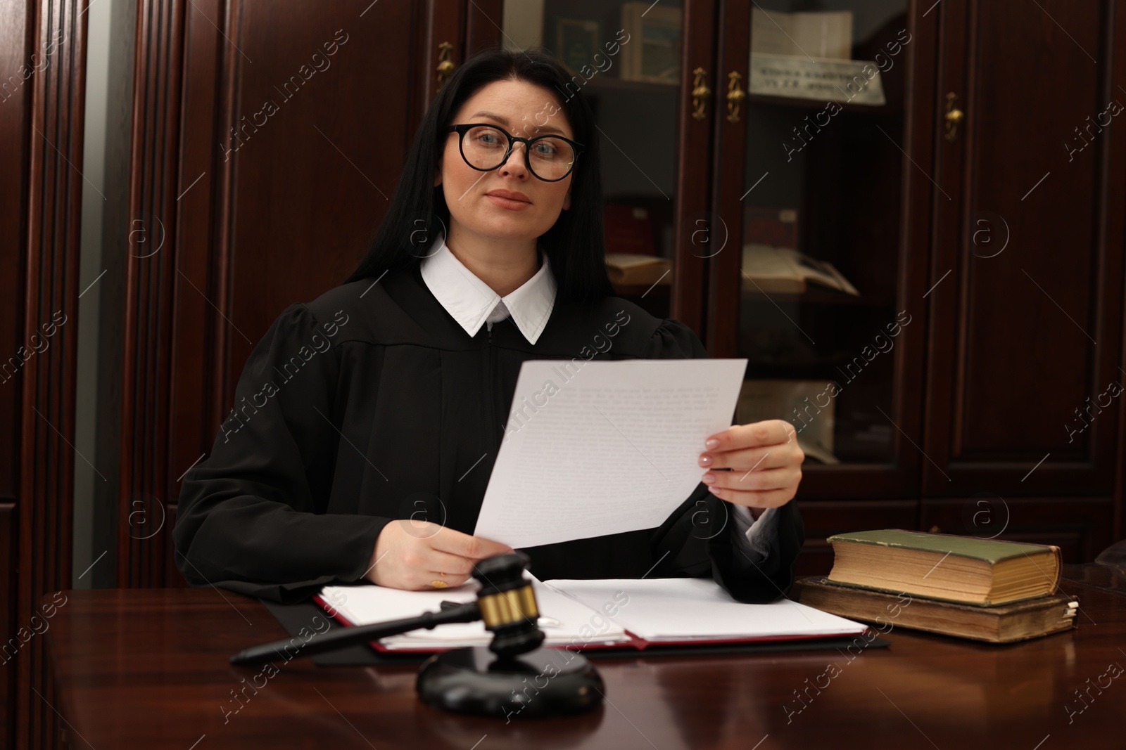 Photo of Judge with document at table in office