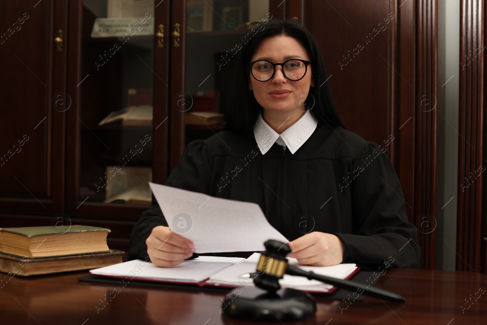 Photo of Judge with document at table in office