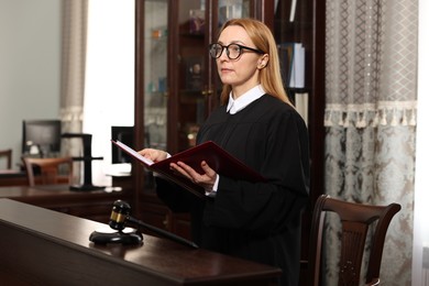 Photo of Judge with folder of documents in courtroom