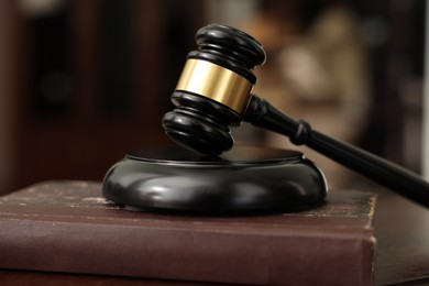 Photo of Judge workplace with gavel and book indoors, closeup