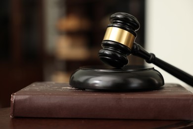 Photo of Judge workplace with gavel and book indoors, closeup