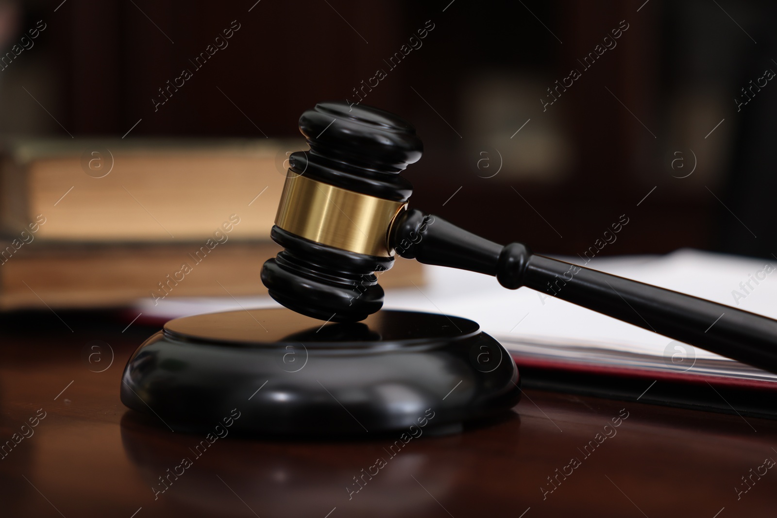 Photo of Judge workplace with gavel and books indoors, closeup