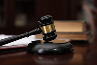 Photo of Judge workplace with gavel and books indoors, closeup