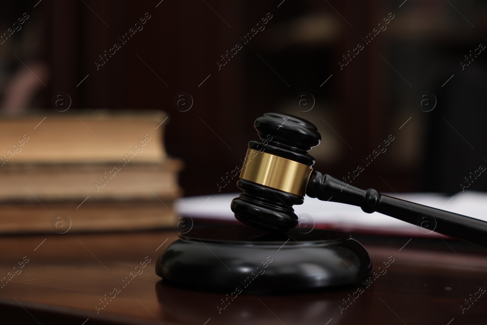 Photo of Judge workplace with gavel and books indoors, closeup. Space for text