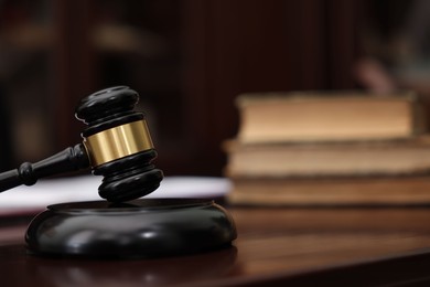 Photo of Judge workplace with gavel and books indoors, closeup. Space for text