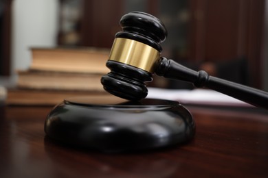 Photo of Judge workplace with gavel and books indoors, closeup