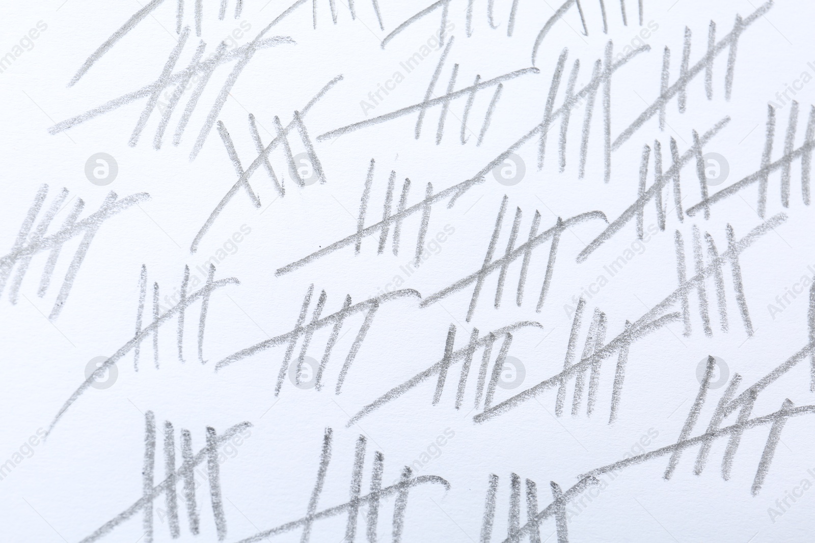 Photo of Counting days by drawing sticks with pencil on white background, closeup