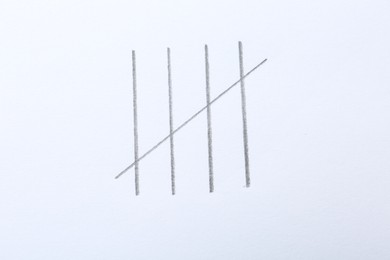 Photo of Counting days by drawing sticks with pencil on white background, closeup