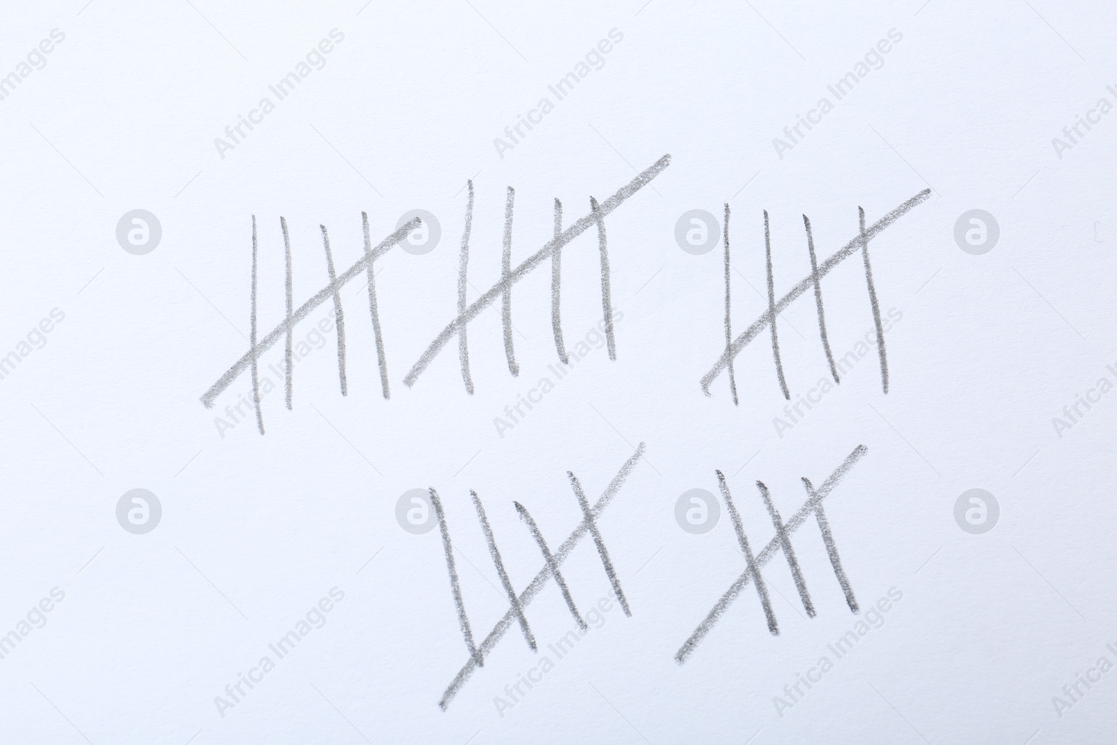 Photo of Counting days by drawing sticks with pencil on white background, closeup