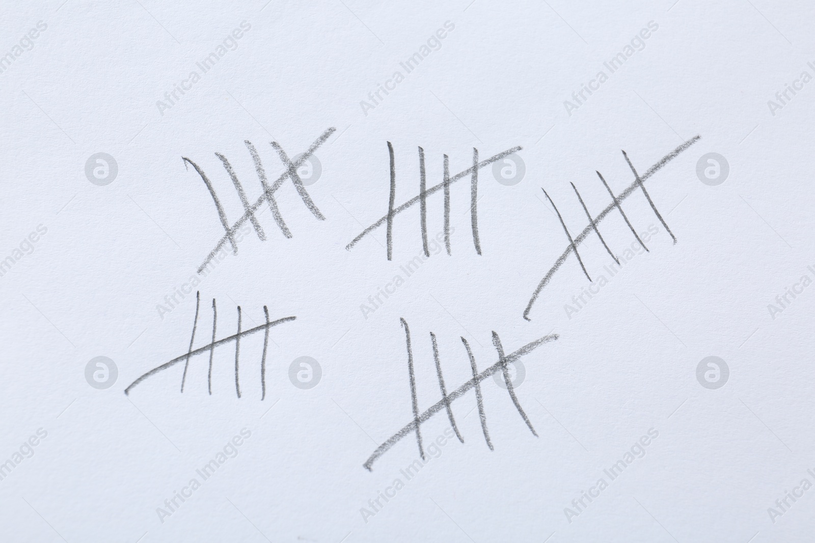 Photo of Counting days by drawing sticks with pencil on white background, closeup