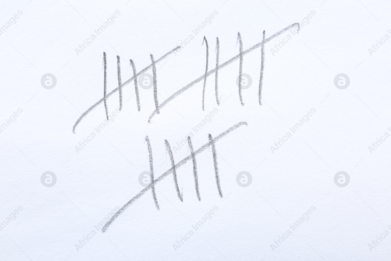 Photo of Counting days by drawing sticks with pencil on white background, closeup