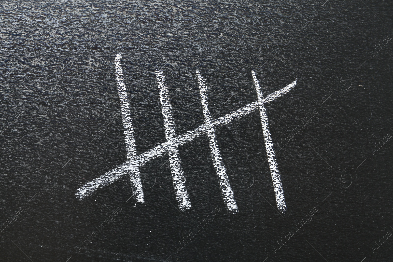 Photo of Counting days by drawing sticks with chalk on blackboard, closeup