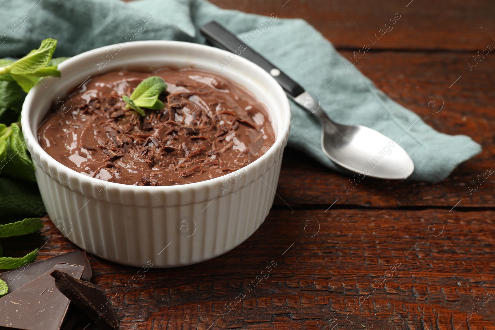 Photo of Tasty chocolate pudding in bowl on wooden table, closeup