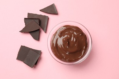 Photo of Delicious chocolate mousse in glass bowl on pink background, top view